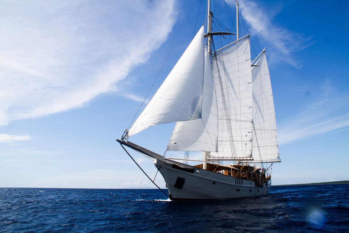 Mutiara Laut Yacht Side Profile Full Sails Bright Blue Sky